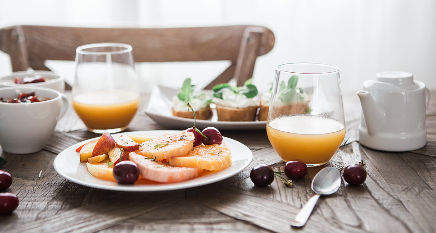 plate a fruit and teo glasses of juice