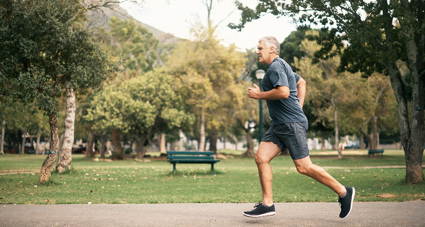 an older man running in a park